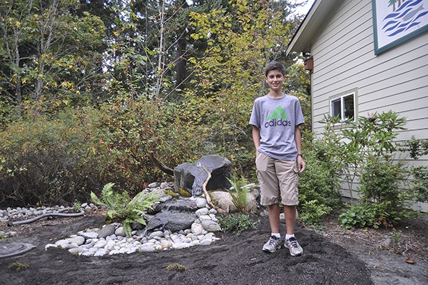 Sequim youth Sean Weber stands next to his water feature at the Dungeness River Audubon Center.