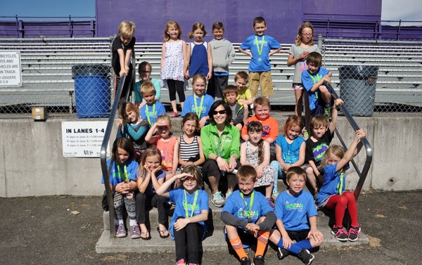Cougar Running Club members from Ione Marcy’s first-grade class at Helen Haller Elementary School enjoy a breather after taking a last run around the high school track. Many of them participated in the NODM Kids’ Marathon on June 4 and wore their T-shirts and medals to school on the Monday after.