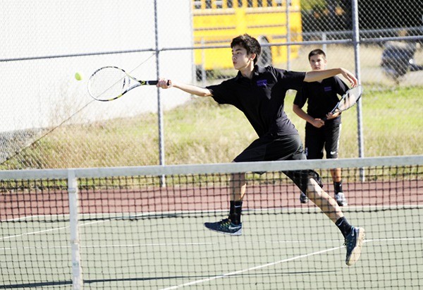 Raymond Lam returns a serve while teammate Blake Wiker looks on in a match against the North Mason Bulldogs on Sept. 20. The Wolves swept the matches 7-0 on the day.