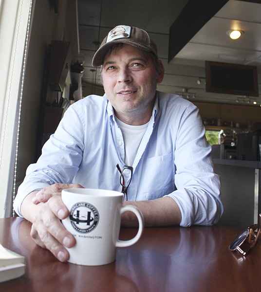 Sequim author Jonathan Evison pauses over his tea during an interview at Hurricane Coffee. His soon-to-be-released novel
