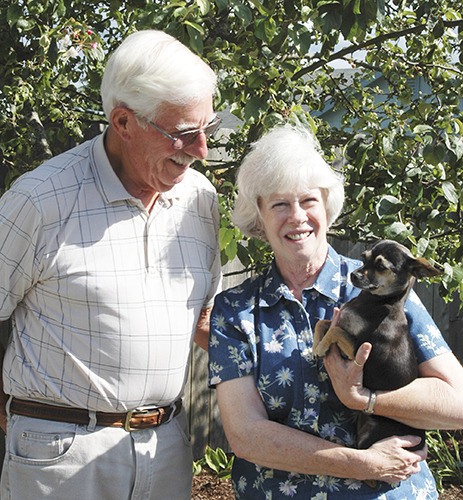 Dart and Margie Whitmore stand in their beautifully landscaped backyard with their recently adopted dog