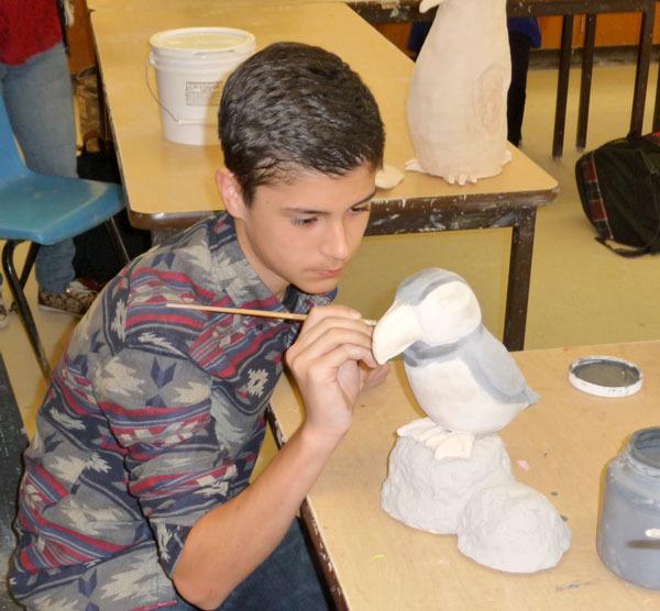 Sean Weber carefully adds glaze to his puffin.