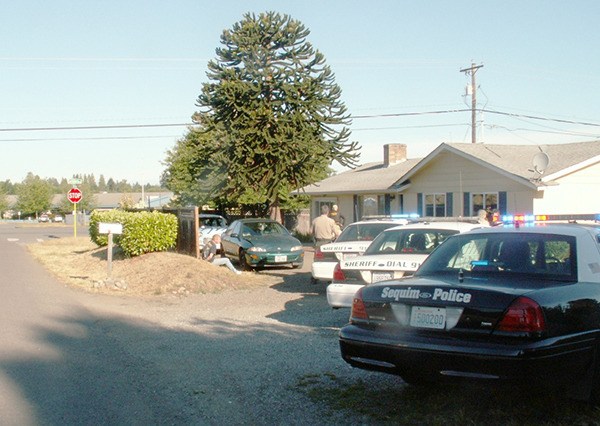 Law enforcement personnel serve a search arrant at a Carlsborg residence on June 25. Four individuals were arrested for their involvement in possession or sale of illegal drugs.