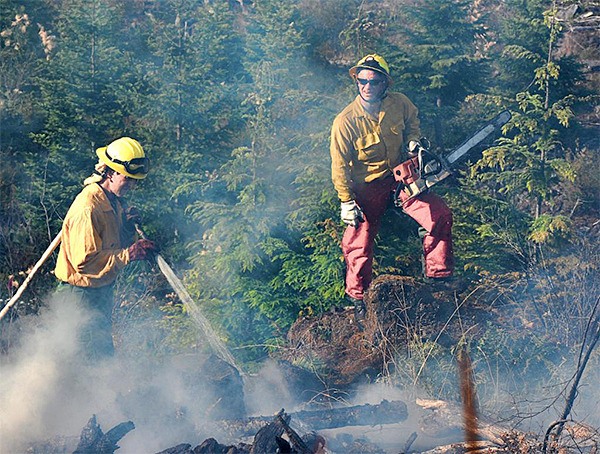 Firefighters from Clallam County Fire District 2 work on a brush fire recently near Lake Sutherland.