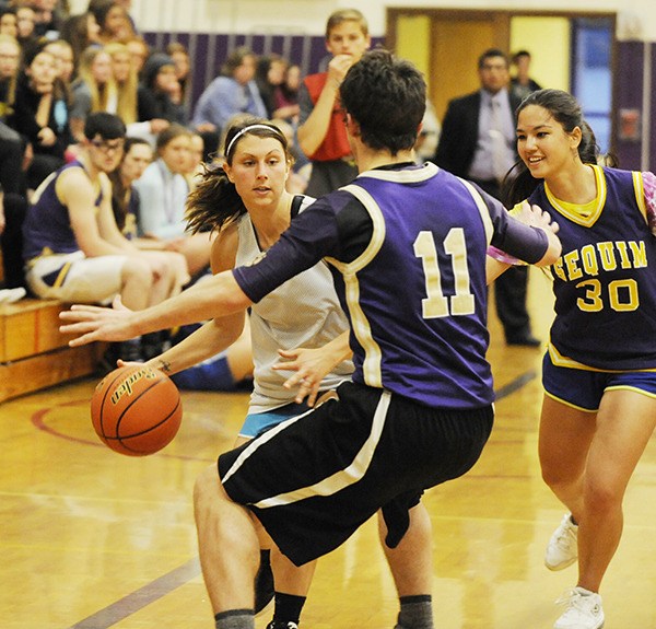 SHS teacher Justine Wagner dribbles the ball upcourt as she’s guarded by Sequim High seniors Alex Rutherford and Cheyanne Sokkoppa.