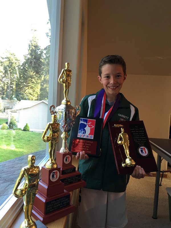 Sequim’s Garrett Little shows off some of the trophies and awards he’s won from district