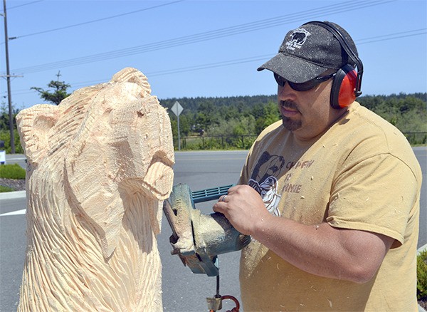 Ray Schulz works on a bear he’s carving for the Captain Joseph House Foundation.