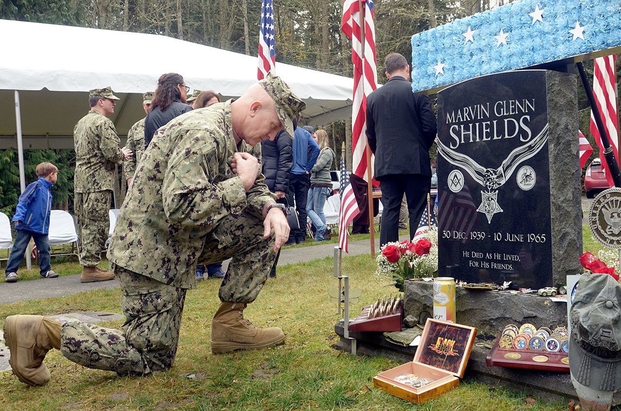 Capt. Christ Kurgan crosses himself beside the grave of Medal of Honor recipient Marvin Shields during the annual Veterans Day ceremony at the Gardiner Cemetery on Friday. Photo by Cydney McFarland/Peninsula Daily News