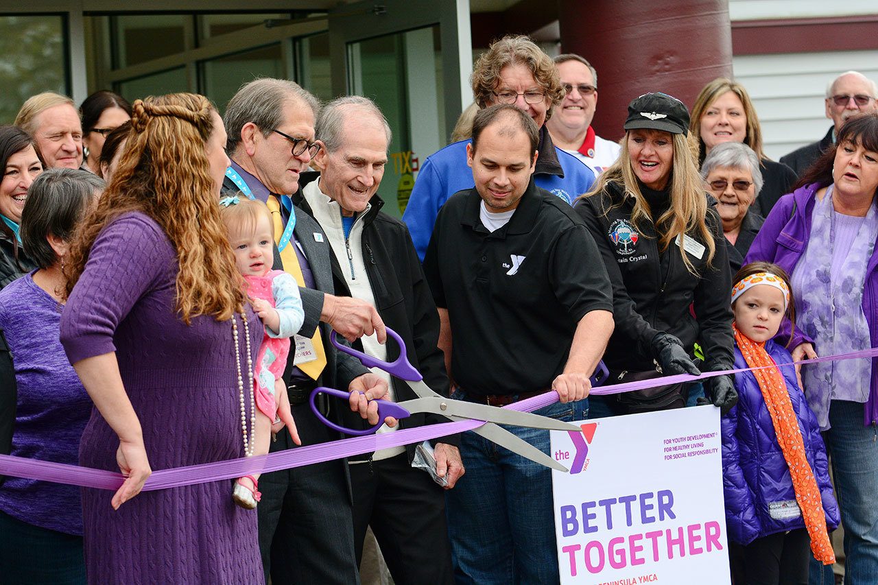 Len Borchers, Olympic Peninsula YMCA CEO, cuts the ribbon during the grand opening of the YMCA of Sequim on Sunday. (Jesse Major/Peninsula Daily News)