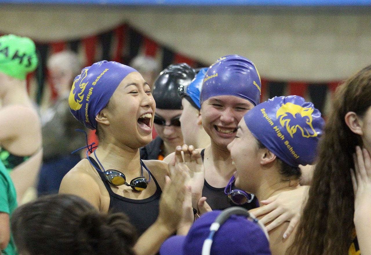 Sequim teammates, from left, Jasmine Itti, Sonja Govertsen and Sydnee Linnane celebrate one of their relay teams making the 2A state tournament at the districts meet. Not pictured is Anna Miehe. Photo by Madeline Patterson