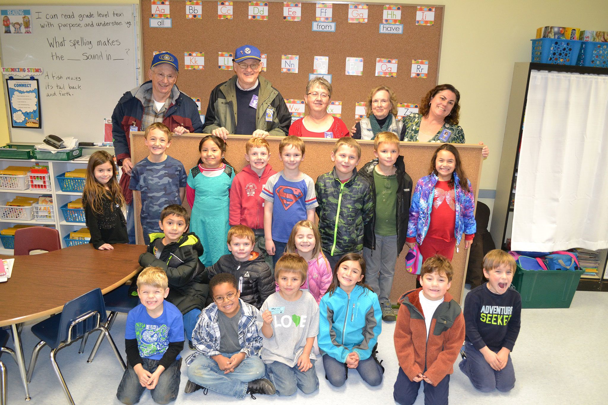 Members of the Sequim-Dungeness Kiwanis, from top left, Wayne Boden, Ted Lund and Philomena Lund stand with Nan Burris of Sequim Community Helping Kids helped coordinate and construct four new bulletin boards for Jennifer Saul, top right, and her first-grade classroom in Helen Haller Elementary. Sequim Gazette photo by Matthew Nash