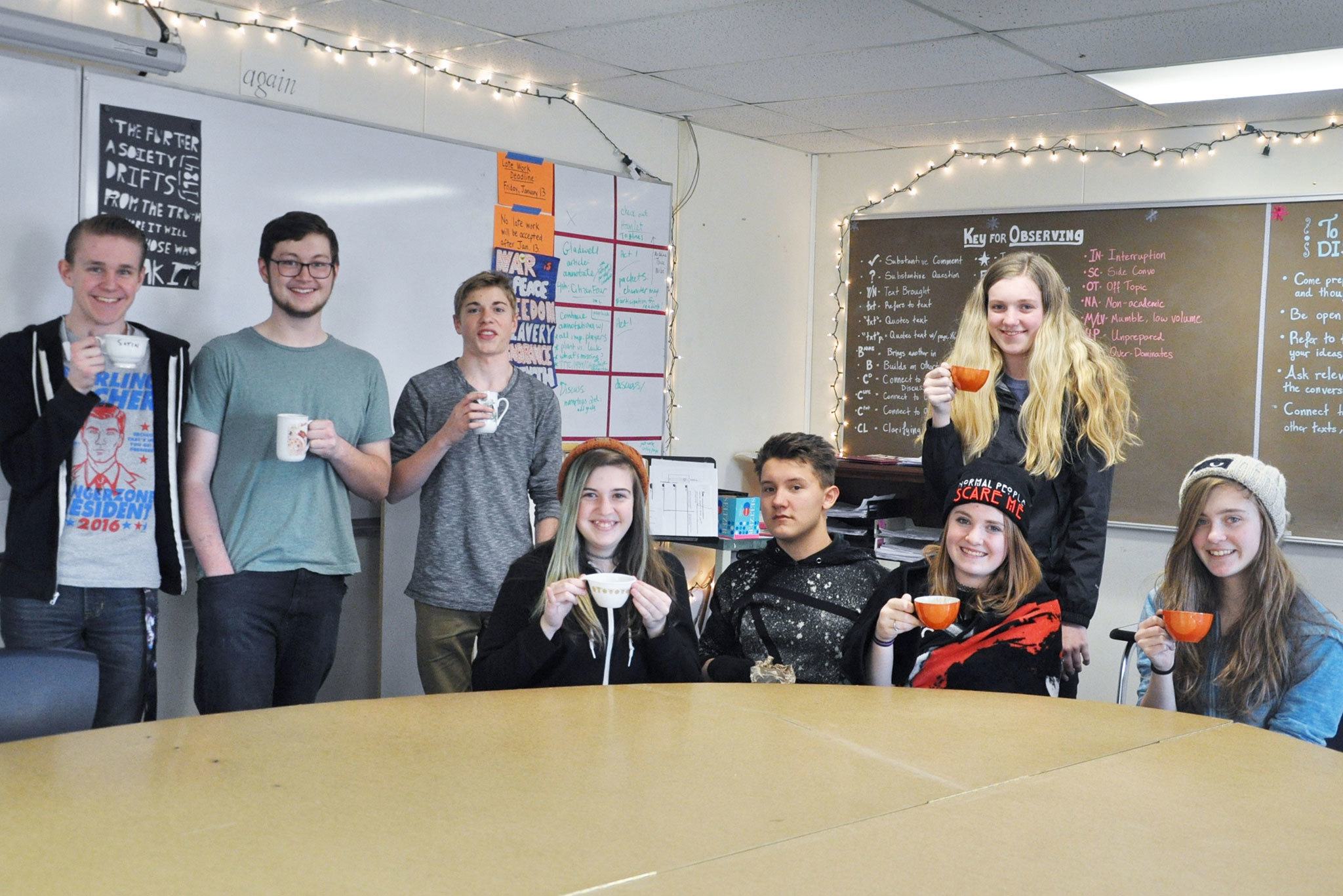 Sequim High School students (from left) Christopher Heintz, Riley Chalk, Seth Johnson, Angeli Chandler, Michael Cole, Madison Grider, Irie Reeder (standing) and Izzy Gawley gather in Nellie Bridge’s classroom one day each week after school to sit, sip tea and chat together. Photo by Patsene Dashiell