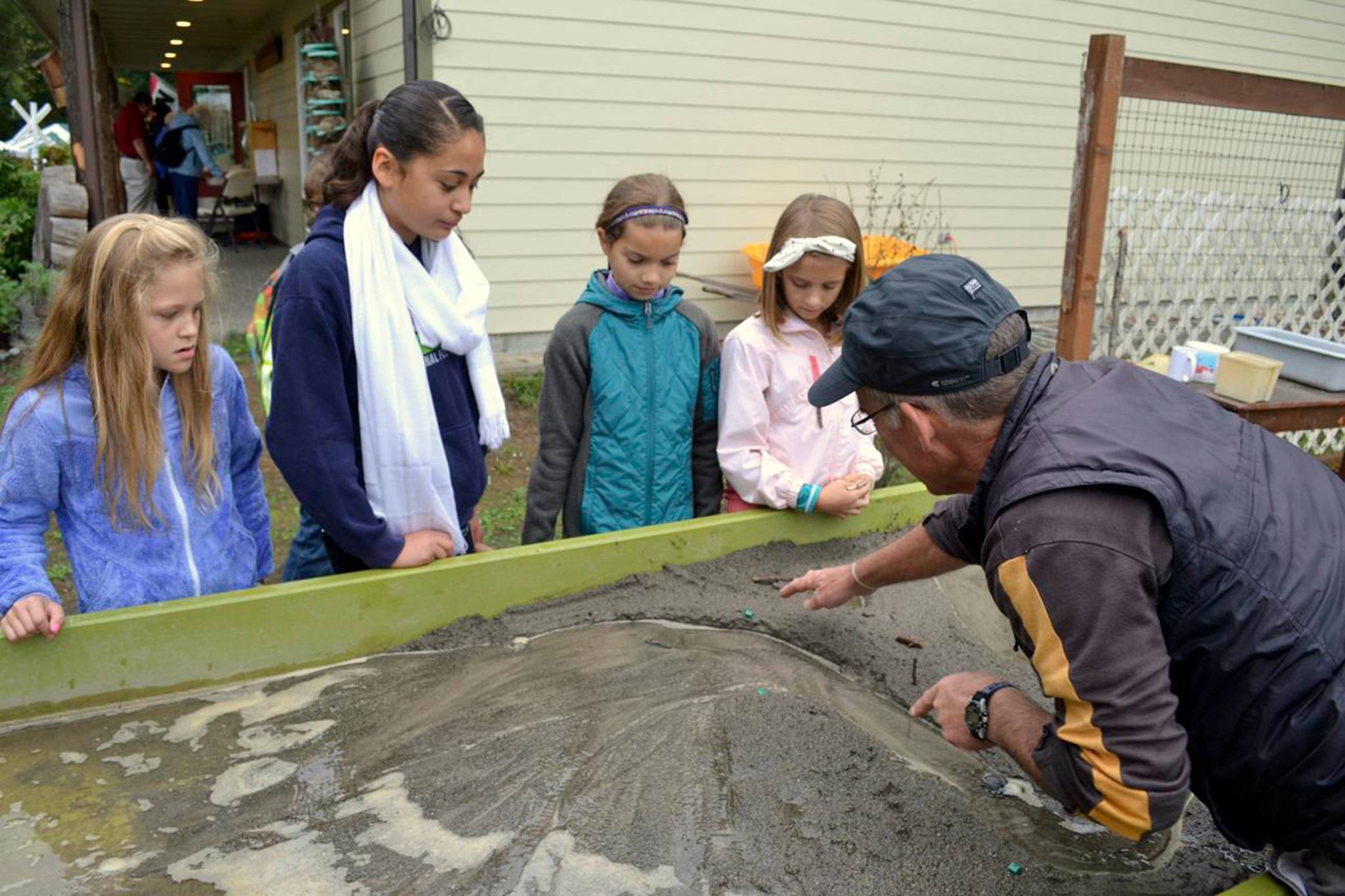 Sequim students, from left, Claire D’Amico, Genesis Lopez, Kari Olson and Julie Jack listen to Tom Butler of the Dungeness River Audubon Center speak about how a river behaves at the Dungeness River Festival in September 2015. Community partners recently announced plans to expand the center to offer more educational projects and other services. Sequim Gazette file photo by Matthew Nash
