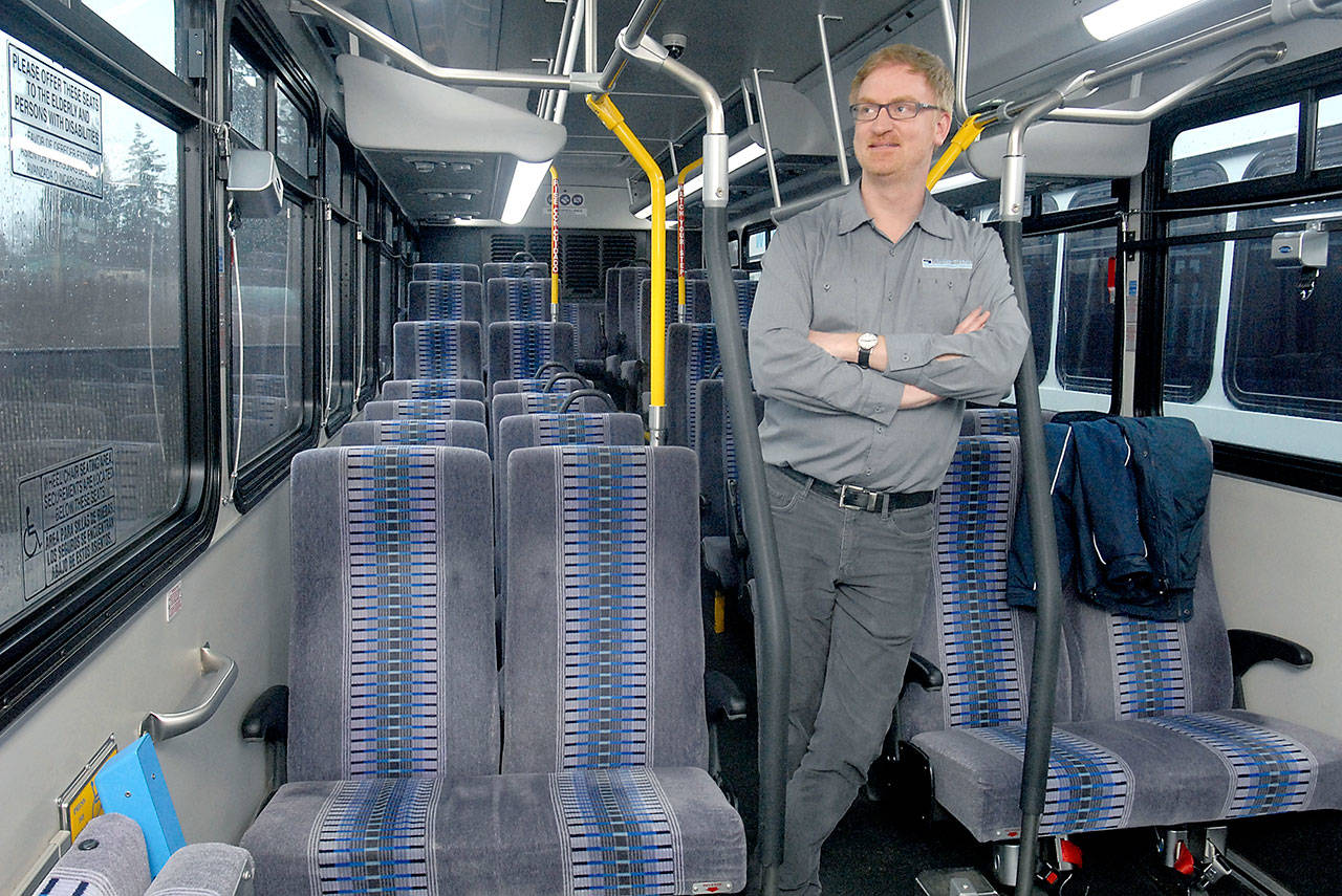 Clallam Transit operations manager Steve Hopkins stands in the aisle of a bus similar to the rolling stock being considered for a twice-daily run from Port Angeles and Sequim to Bainbridge Island. Keith Thorpe/Peninsula Daily News