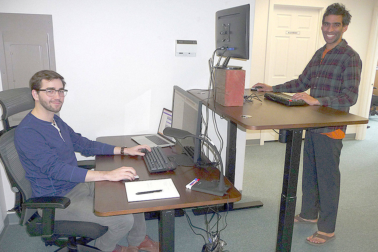 Edward Unthank, left, and Ankur Shah, right, display two different work station configurations at Clallam Coworking. Sequim Gazette photo by Patricia Morrison Coate