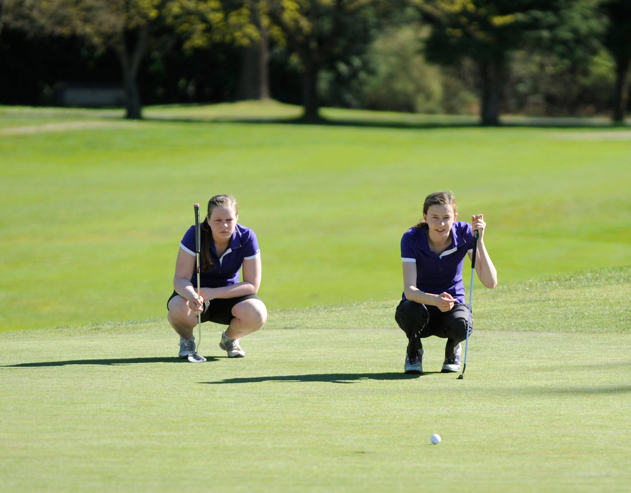 Sequim’s Sarah Shea and Alex McMenamin, seen here eyeing a putt at The Cedars at Dungeness last March, are the girl squad’s No. 2 and No. 1 varsity players. McMenamin, a senior, won the Olympic League MVP three years in a row. Sequim Gazette file photo by Michael Dashiell