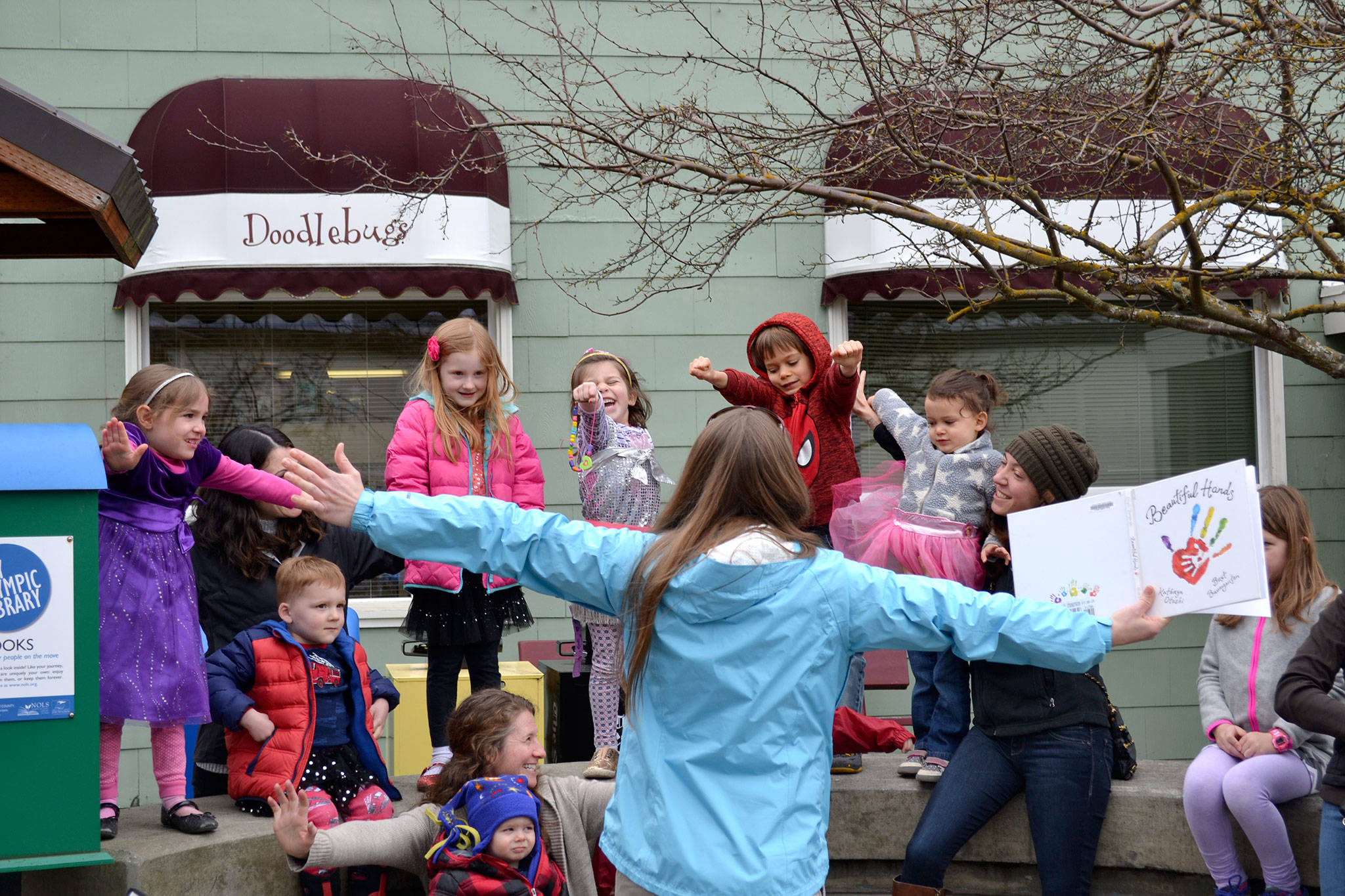 Emily Sly reads “Beautiful Hands” to a group of families for the “Love Sparkle the World” project on March 20 in Seal Street Park that encourages families to show children they are loved through reading. Sequim Gazette photo by Matthew Nash