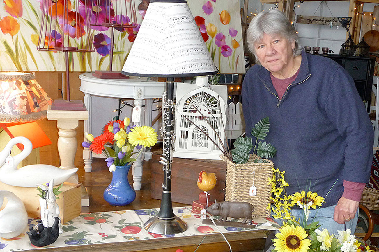 J. Brzoska, owner of The Rusting Rooster, knows a “cool find” when she sees one. She displays one of her favorites, a clarinet she repurposed into a table lamp. Sequim Gazette photo by Patricia Morrison Coate