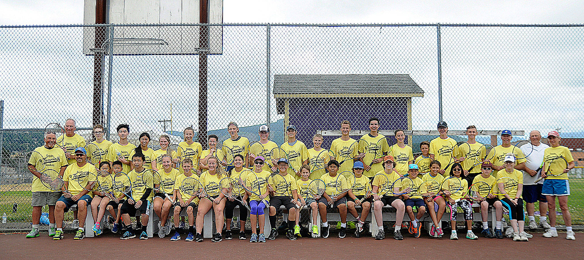 Participants and volunteers/coaches at the Sequim Tennis Academy take a break from activities at the Sequim High School courts last week. Sequim Gazette photo by Michael Dashiell