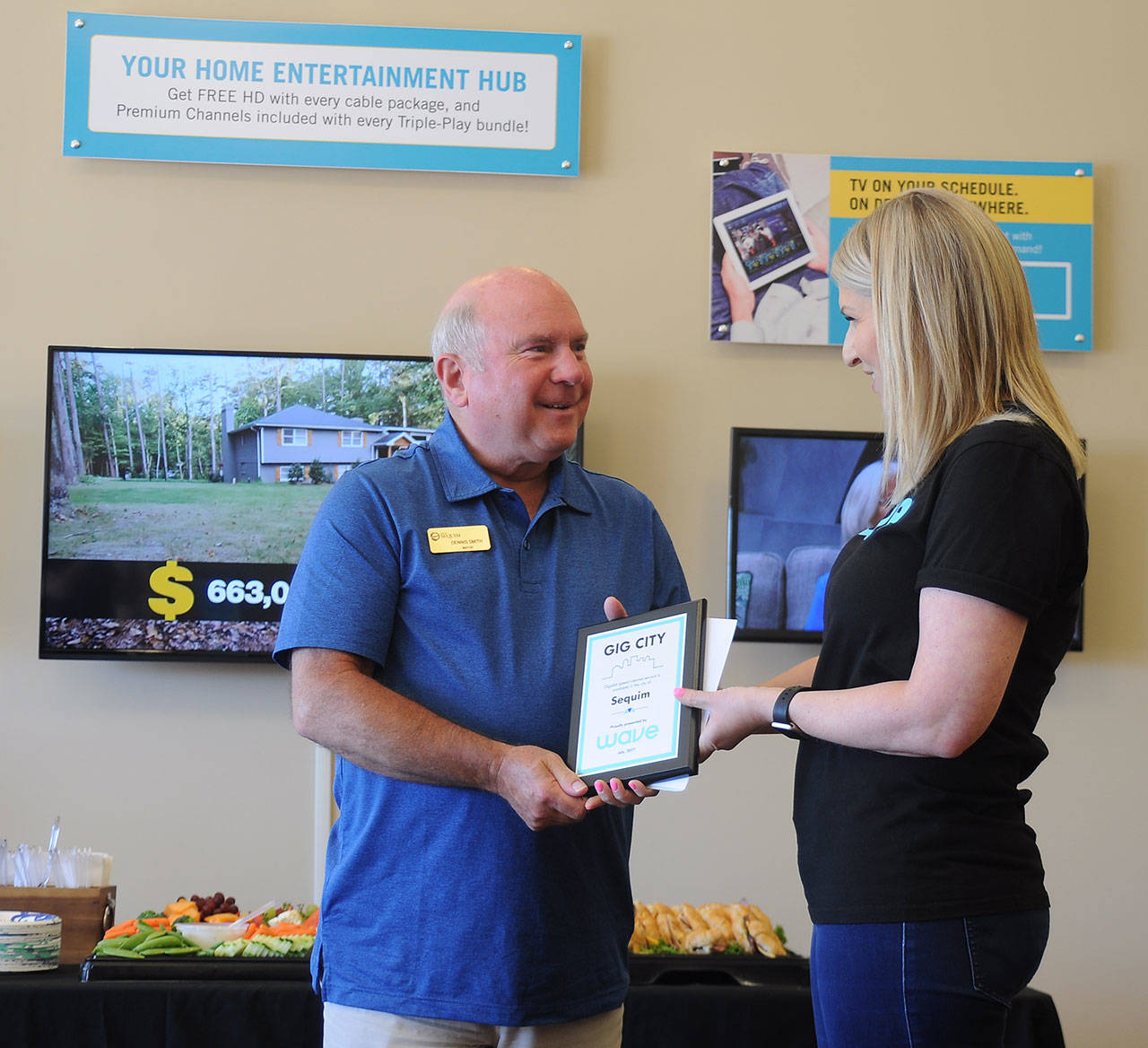 Mayor Dennis Smith accepts the “Gig City” plaque from Emily Moore, a Wave Broadband representative, at the launch of its gigabit service.                                 Sequim Gazette photo by Patricia Morrison Coate