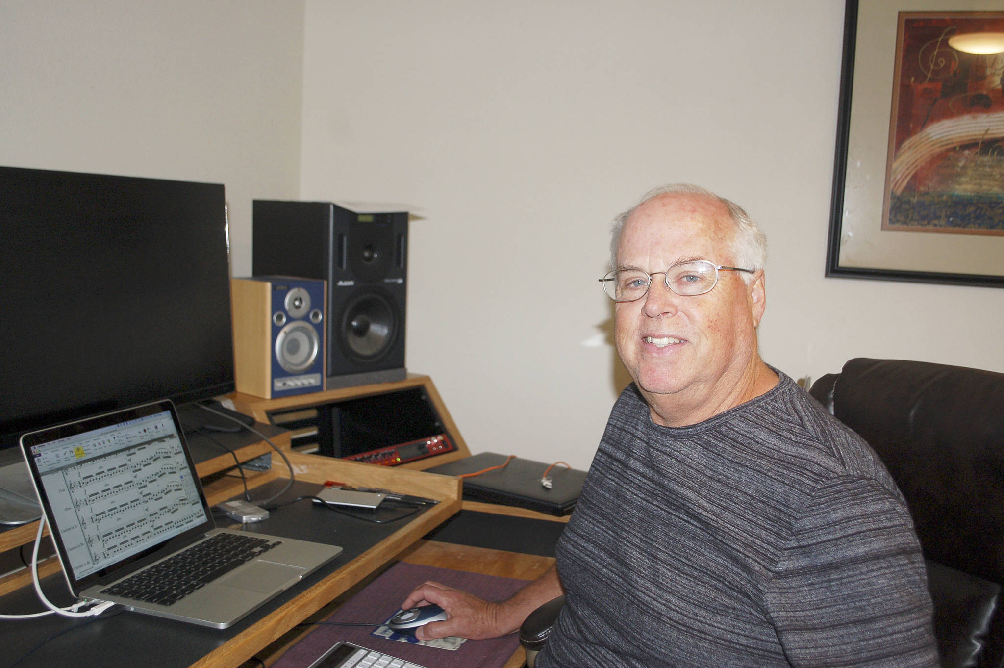Sequim musician and music-tech educator Mike Klinger sits at his desk in his home music studio demonstrating how to use music and technology together. Sequim Gazette photo by Erin Hawkins