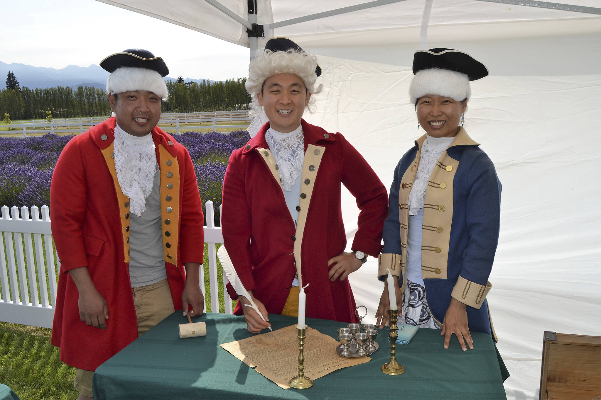 Friends from Seattle, from left, Peter Cher, Jung Jim and Jin Lim dress the part for a photo-op as they prepare to sign the Declaration of Independence. Lim said wasn’t able to make Sequim Lavender Weekend so she came up for the NW Colonial Festival. Sequim Gazette photo by Matthew Nash