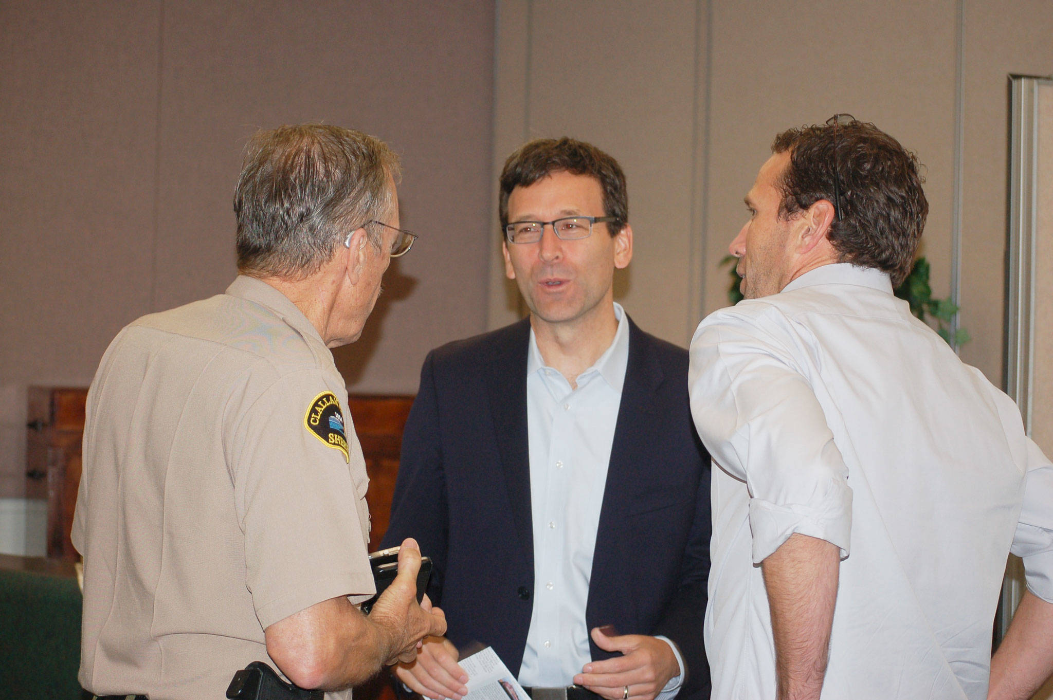 Washington State Attorney General Bob Ferguson, center, talks with Clallam County Sheriff Bill Benedict, left, and Rotary members after the Sequim Sunrise Rotary meeting on Friday, Aug. 18, where he stopped to pay a visit on his way to the ceremony naming the Daniel J. Evans Winderness at Hurricane Ridge. Sequim Gazette photo by Erin Hawkins
