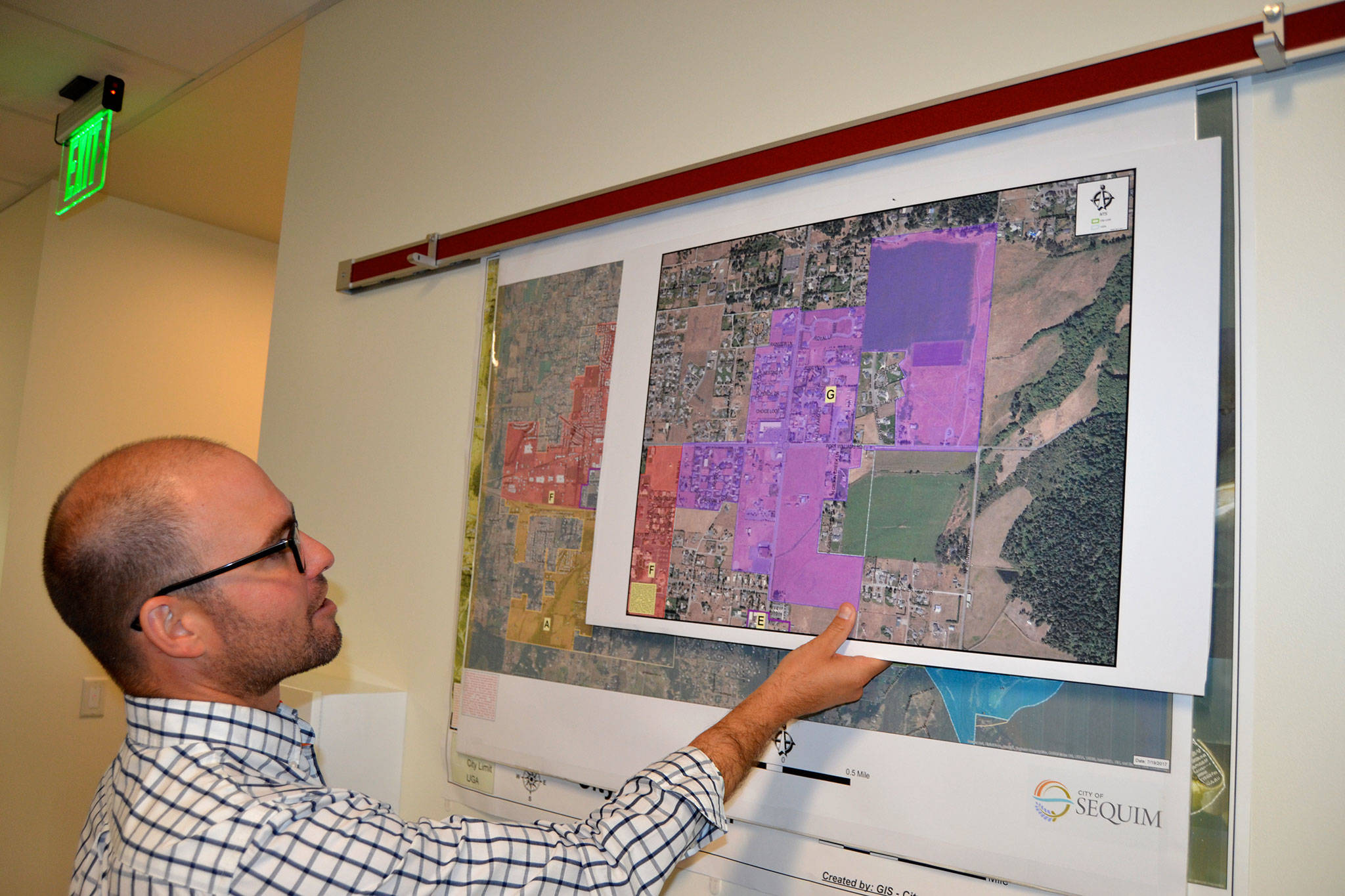 Sequim Assistant City Manager Joe Irvin holds maps of different regions in the City of Sequim that staff hope residents, churches and business owners will help them pinpoint issues and opportunities in their areas at a Neighborhood Visioning Meeting on Sept. 9, in the Guy Cole Center. Sequim Gazette photo by Matthew Nash