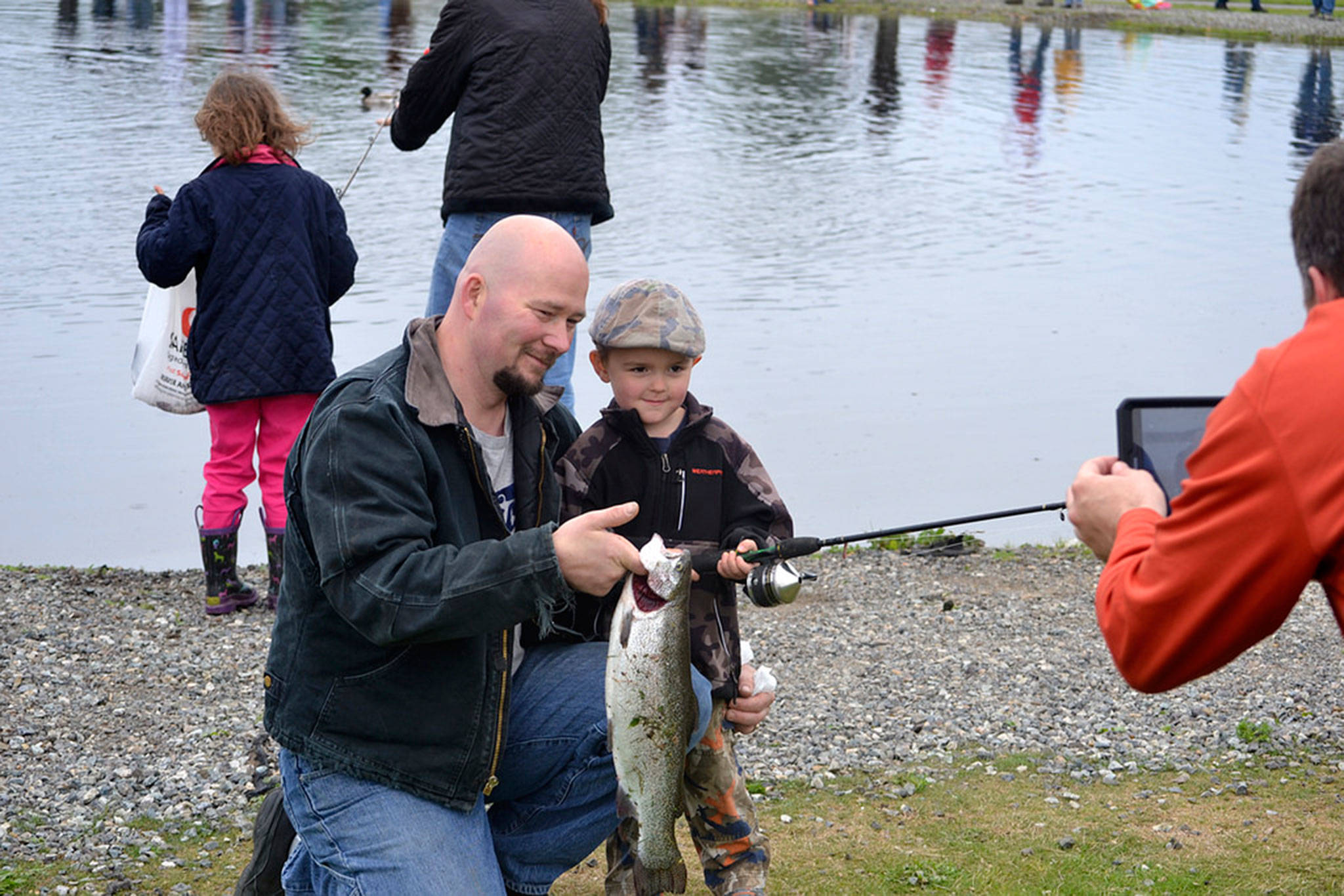 Father and son Carl and Kenneth Cook of Sequim show off Kenneth’s first ever caught fish for a photo-op at Kids Fishing Day in Carrie Blake Community Park in 2016. Organizers are considering moving the pond to keep the fish healthy and safe as conditions fluctuate in the current pond. Sequim Gazette file photo by Matthew Nash