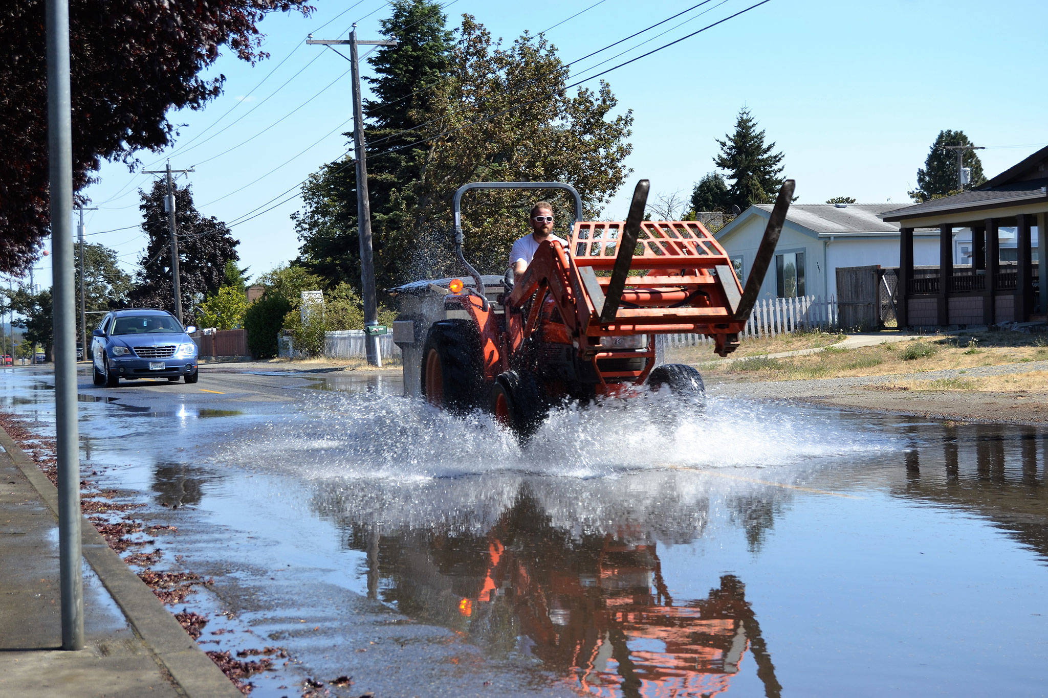In 2018, staff with the City of Sequim anticipate construction beginning on rebuilding Fir Street from Sequim Avenue to Fifth Avenue. The road is bumpy and sometimes floods, seen here in late August when a Sequim School District employee drives through. Sequim Gazette photo by Matthew Nash