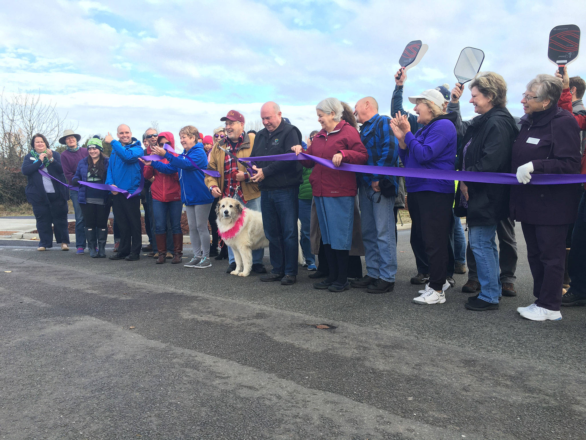 Sequim mayor Dennis Smith cuts the ribbon on the entrance to Carrie Blake Community Park on Nov. 20. The new road to the park finished on Oct. 30 and increases safety as it deters vehicle traffic away from playgrounds. Sequim Gazette photo by Matthew Nash