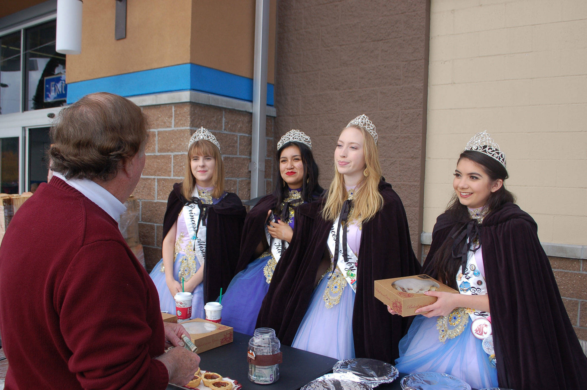 Lew Morris makes a donation to the 2017 Irrigation Festival Royalty Court who sold pumpkin and apple pies outside of the Sequim Walmart on Nov. 22.                                 Sequim Gazette photo by Erin Hawkins