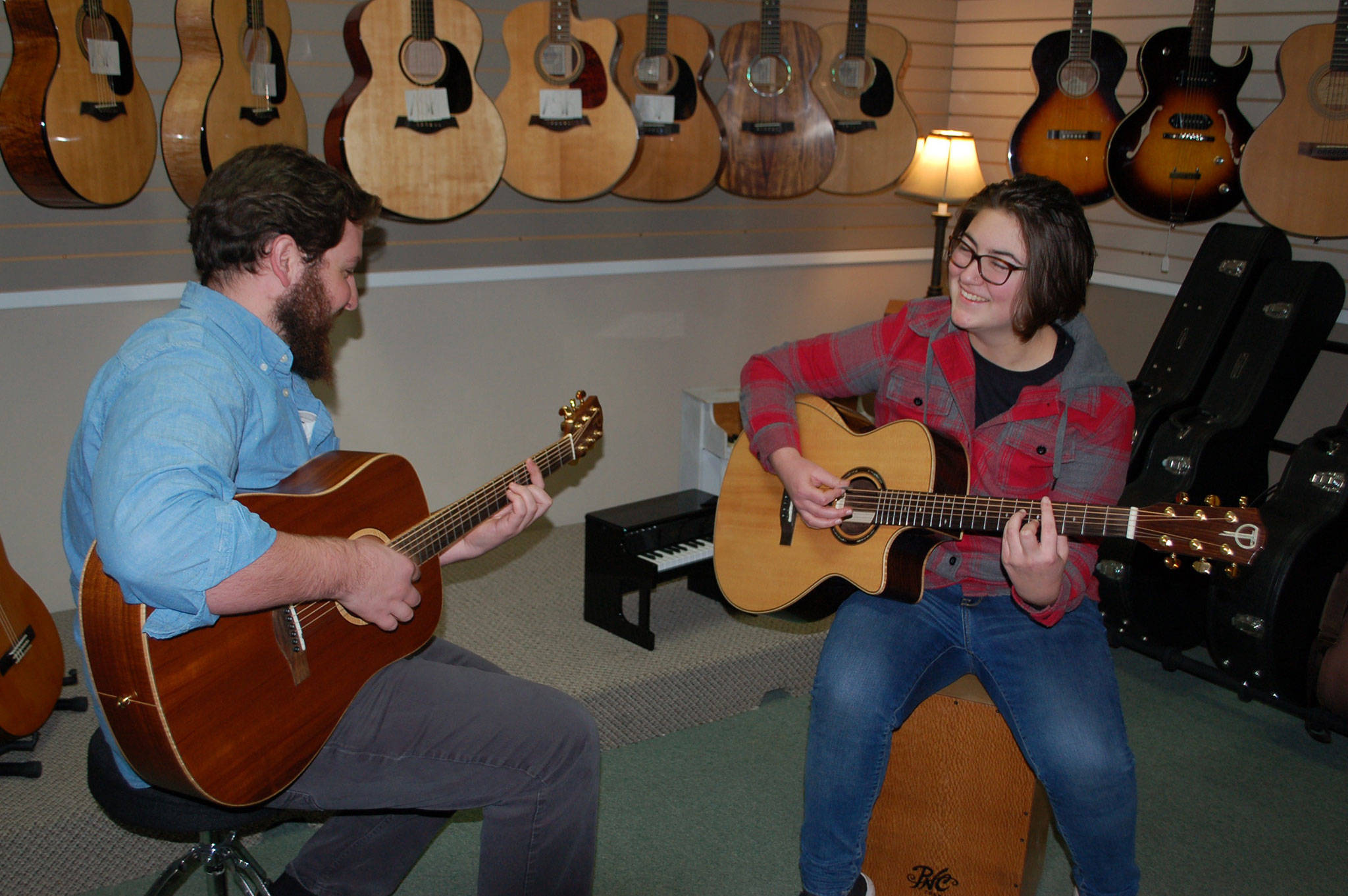 Sequim High School sophomore Kyah Fukunaga (right) tries out her new acoustic-electric guitar she received during the school’s Winter Wishes assembly on Dec. 13. She practices with Joyful Noise Music Center instructor John Mangiameli (left) at the center during a music lesson. Sequm Gazette photo by Erin Hawkins