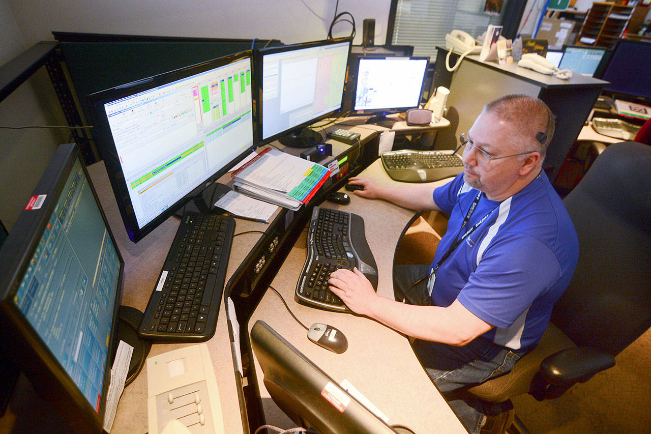 JeffCom Dispatcher Terry Taylor handles a call Tuesday amid a report of a possible capsized boat near the Hood Canal bridge. Calls from that area are frequently routed to the incorrect dispatch center. Photo by Jesse Major/Peninsula Daily News