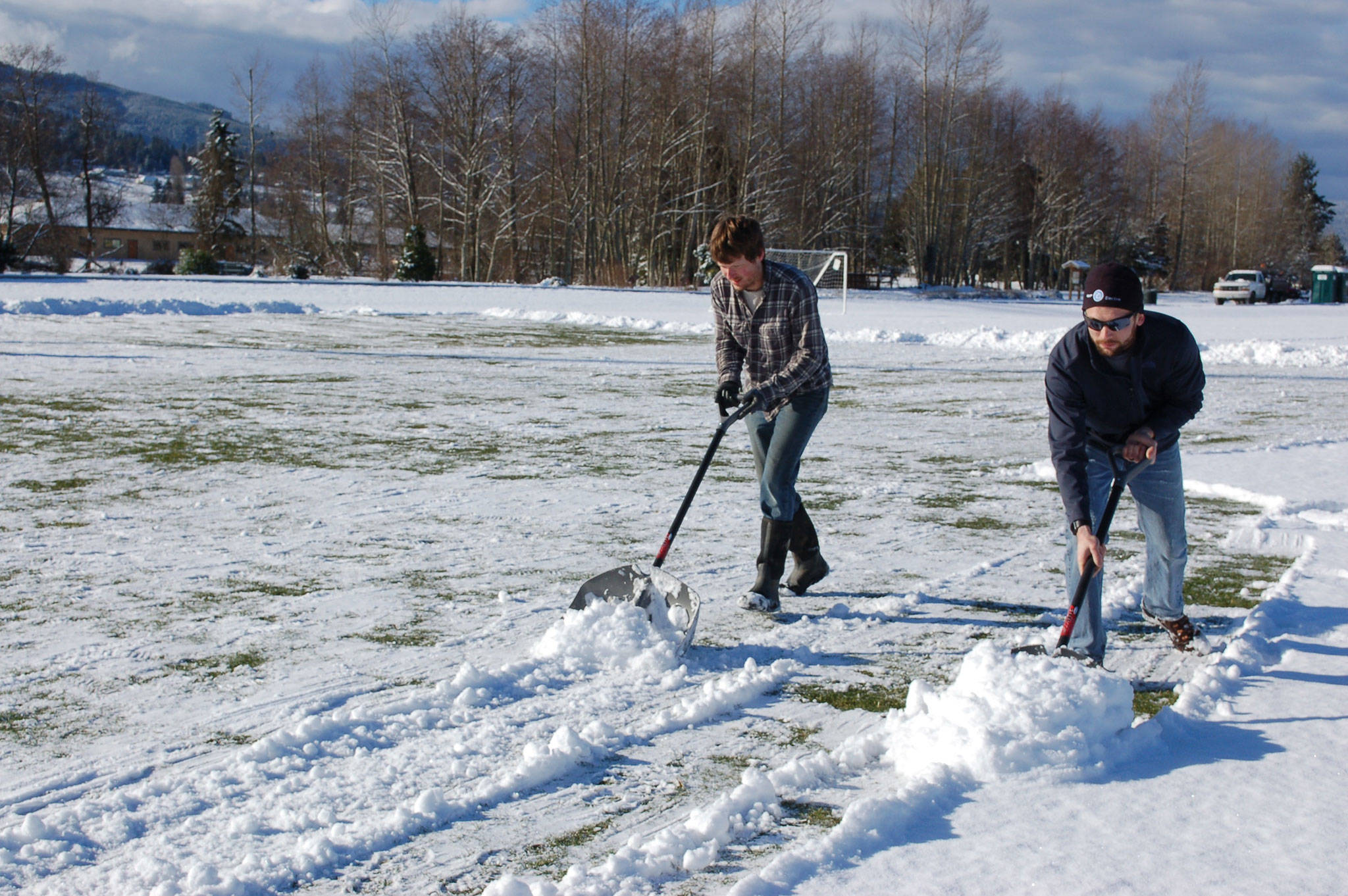 Employee of Meyer Electric, Taylor McCormack, left, and Meyer Electric owner and president of Storm King Soccer Club Kyle Kautzman, shovel snow on Feb. 22 at the Albert Haller Playfields at Carrie Blake Park so the Storm King Soccer Club’s Boys U10 team can practice for their game on Feb. 24. Sequim Gazette photo by Erin Hawkins