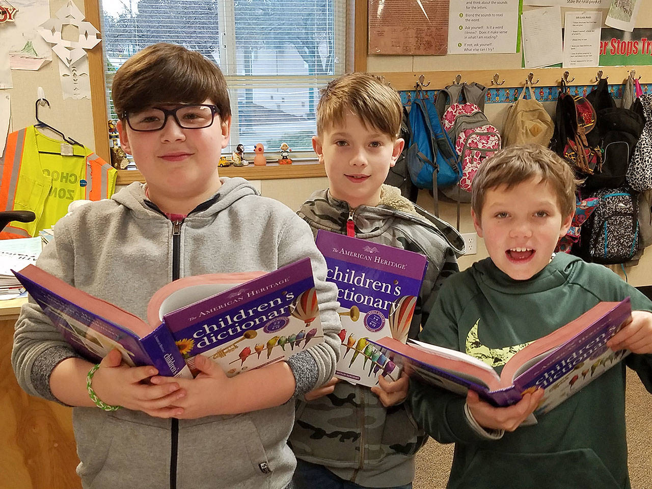 Korey Apley, Kayden Disinski and Ryan Spelker — fourth-grade students in Patrick Caron’s class at Helen Haller Elementary School — check out their new dictionaries, courtesy of Rotary Club of Sequim. Submitted photo