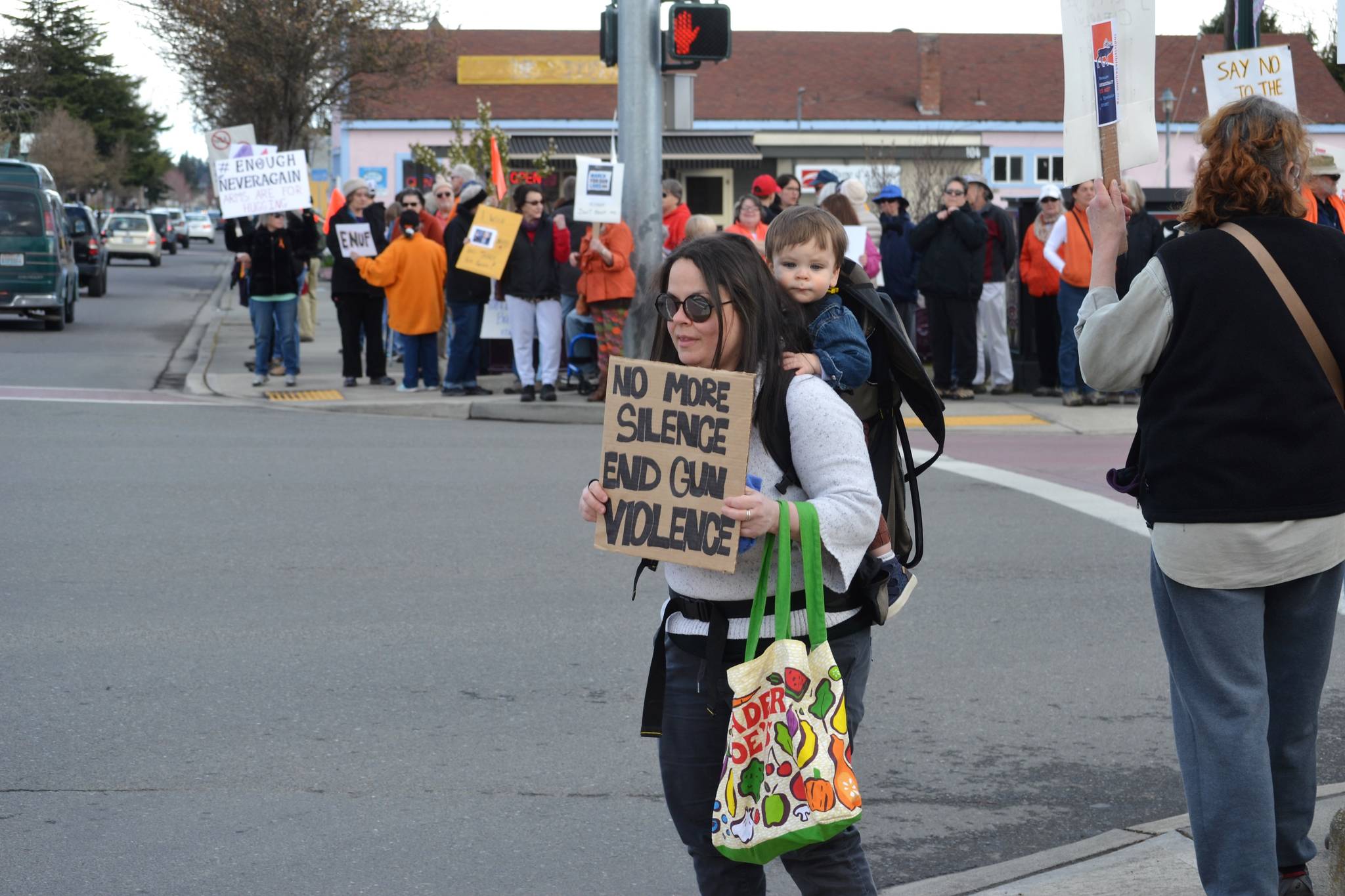 Katie Rodgers of Port Angeles stands with her son Liam, 18 months, on one of the corners of Sequim Avenue and Washington Street in Sequim on March 24 advocating for stricter gun control policies. “I hope it speaks volumes for a small town to show support for an event like this,” she said.