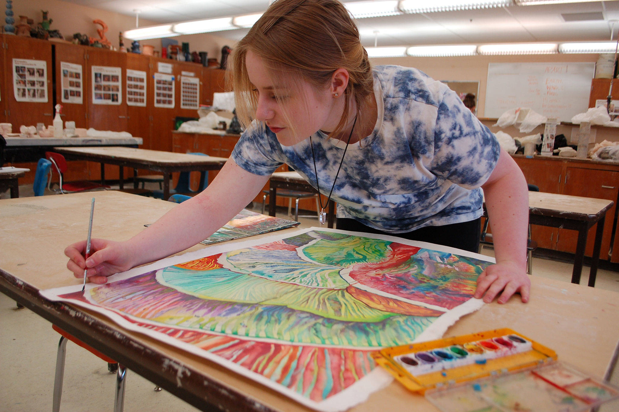 Sequim High School senior Haelee Andres touches up an abstract watercolor painting she is planning to submit to the Sequim Education Foundation Art Show on display at 6 p.m. on Friday, April 20, at the Sequim School District Board room. Sequim Gazette photo by Erin Hawkins