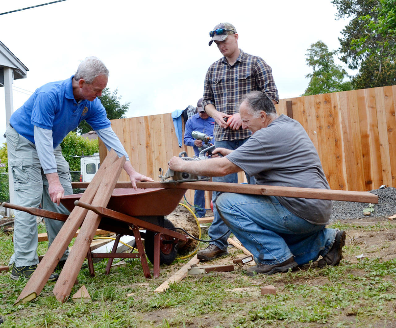 Volunteers from left, Doug Davis, Olin Darby, and John Ketchum, prepare pieces of wood for new fencing at a home in Sequim as part of a Neighborhood Revitalization plan from Habitat for Humanity of Clallam County in 2016. Now the City of Sequim and Habitat partner for Service Fest 2018 this June seeking similar projects from homeowners in city limits. Sequim Gazette file photo by Matthew Nash
