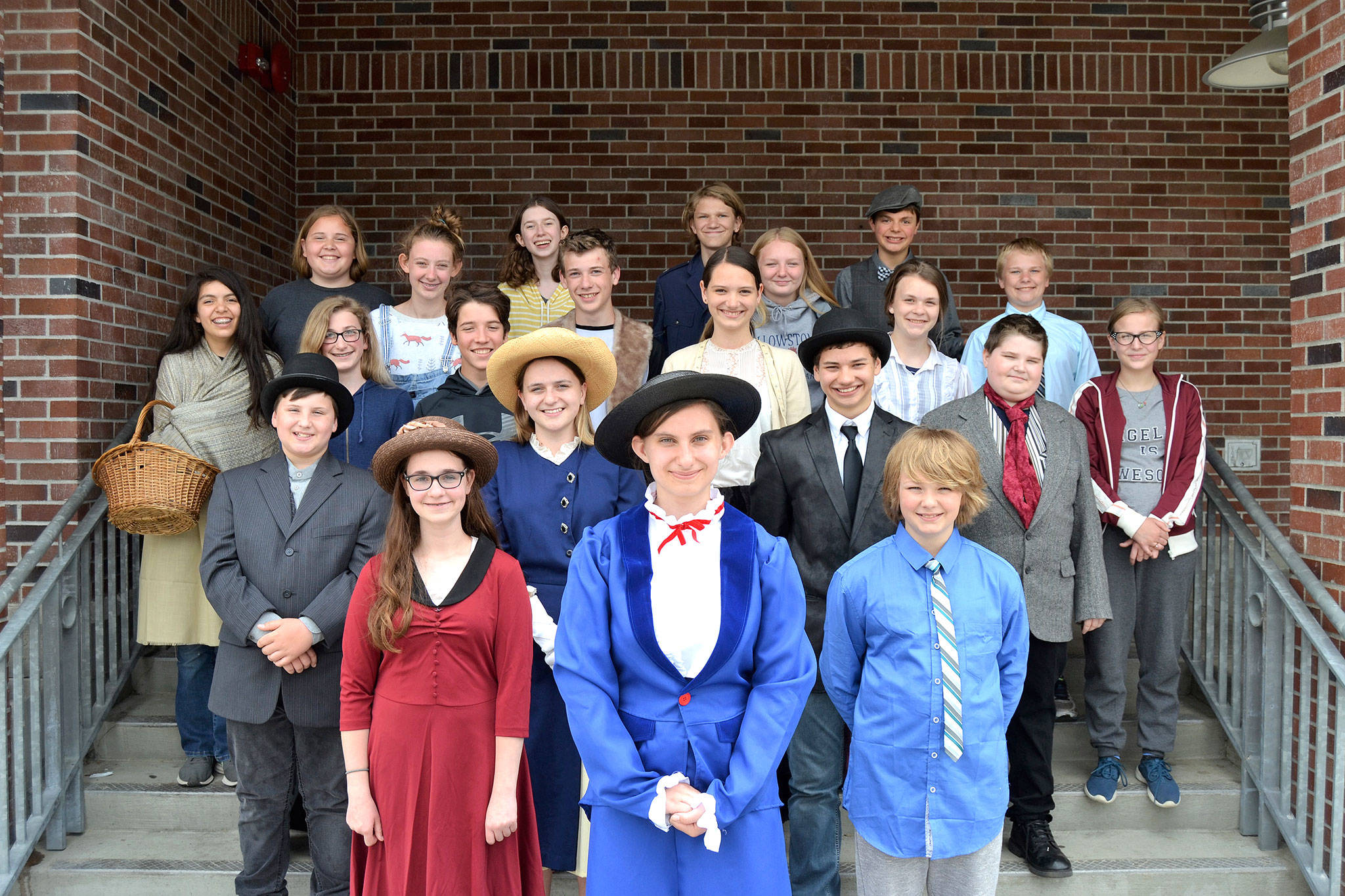 Most of the cast for Olympic Peninsula Academy’s “Mary Poppins JR” gathers outside the Sequim High School Auditorium where they’ll perform four shows including a dress rehearsal at 7 p.m. Thursday, May 31, and regular shows at 7 p.m. Friday, June 1, and 1:30 p.m. and 7 p.m. Saturday, June 2. Sequim Gazette photo by Matthew Nash