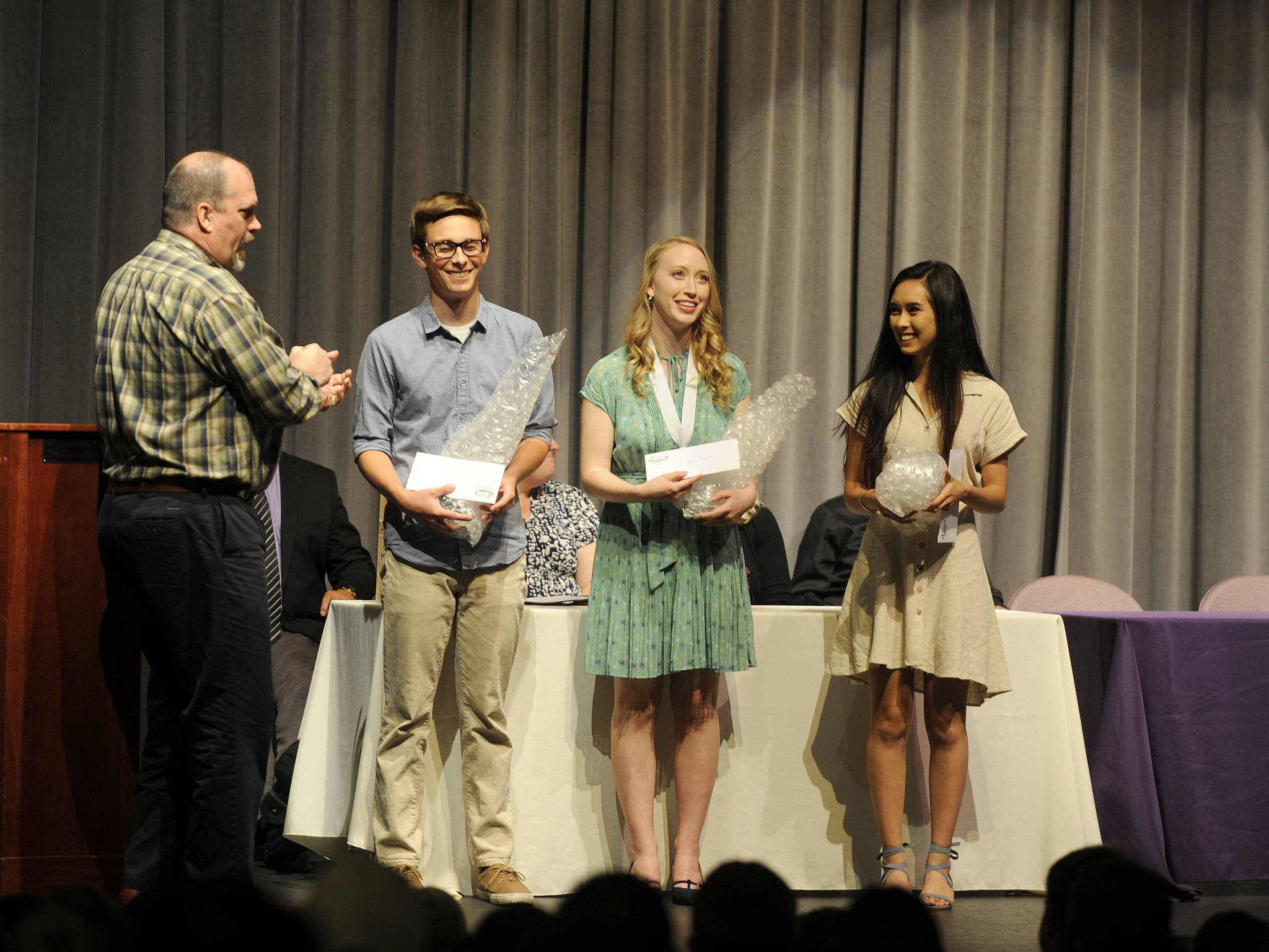Shipley Center Executive Director Michael Smith, left, gives scholarships and trophies along with, as his tradition, some bubble wrap — “Don’t pop pills, pop bubble wrap” — to SHS graduating seniors Josiah Carter, Abby Norman and Andrea Albaugh. Sequim Gazette photo by Michael Dashiell