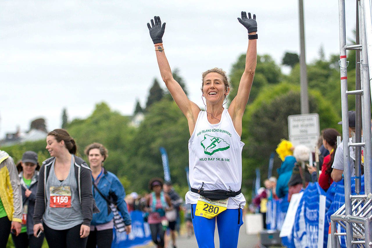 Amy Young of Keaau, Hawaii, celebrates as she crosses the finish line at the North Olympic Discovery Marathon on Sunday. She was the first woman to finish the marathon.