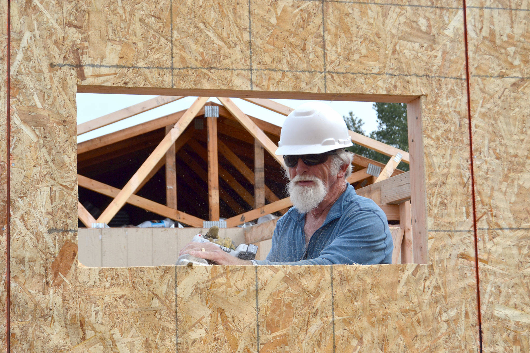 Bill Prichard of Anacortes cuts out a window on a new mower shed in Carrie Blake Community Park. Prichard and his wife are two of 20-plus Care-A-Vanners with Habit for Humanity assisting with neighborhood revitalization projects in Sequim through June 15. Sequim Gazette photos by Matthew Nash