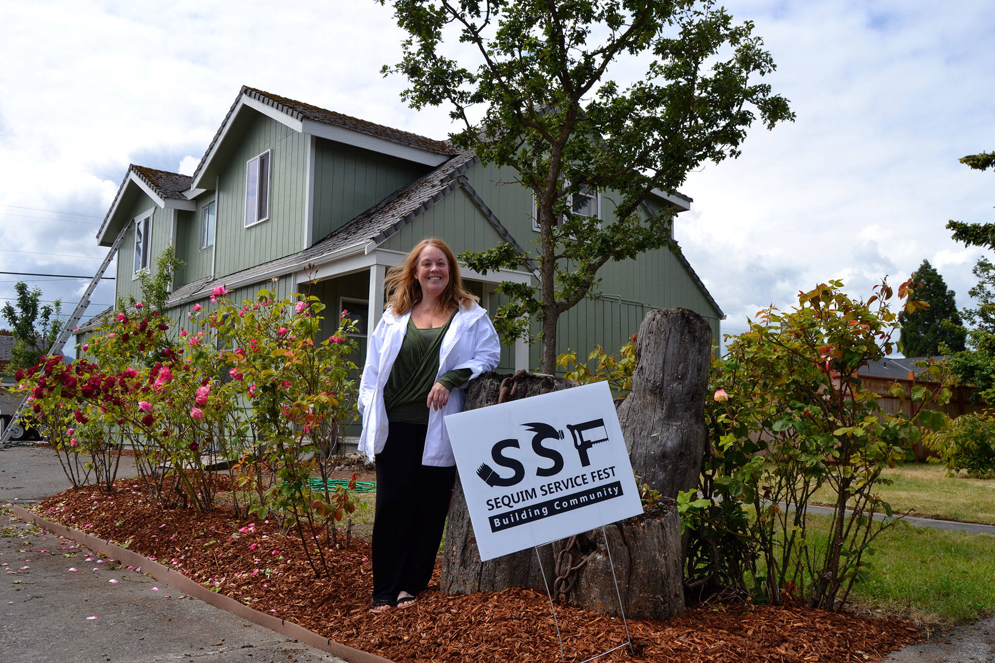Laraine Claire stands outside her home on the corner of Spruce Street and Fourth Avenue where volunteers helped paint and revitalize her home. She said the project helped inspire hope in her. Sequim Gazette photo by Matthew Nash