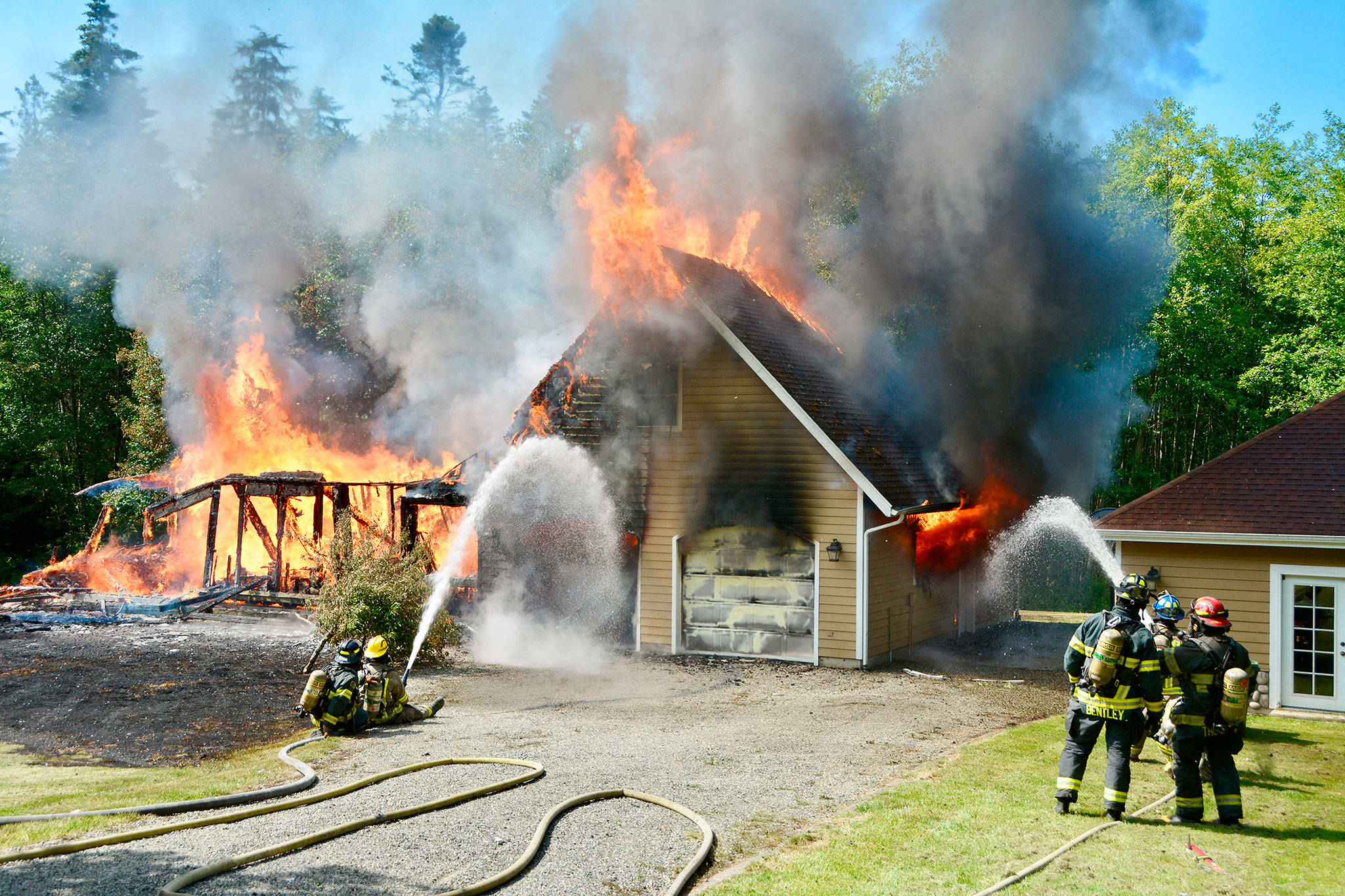Fire crews from District 2 (Port Angeles and 3 (Sequim) respond to a fully involved, two-story structure fire near the end of Lake Farm Road on June 19. All of the occupants had evacuated the house at 131 Pristine Lane, Clallam County Fire District No. 3 Chief Ben Andrews said. Photo by Jay Cline/Clallam Fire District No. 2