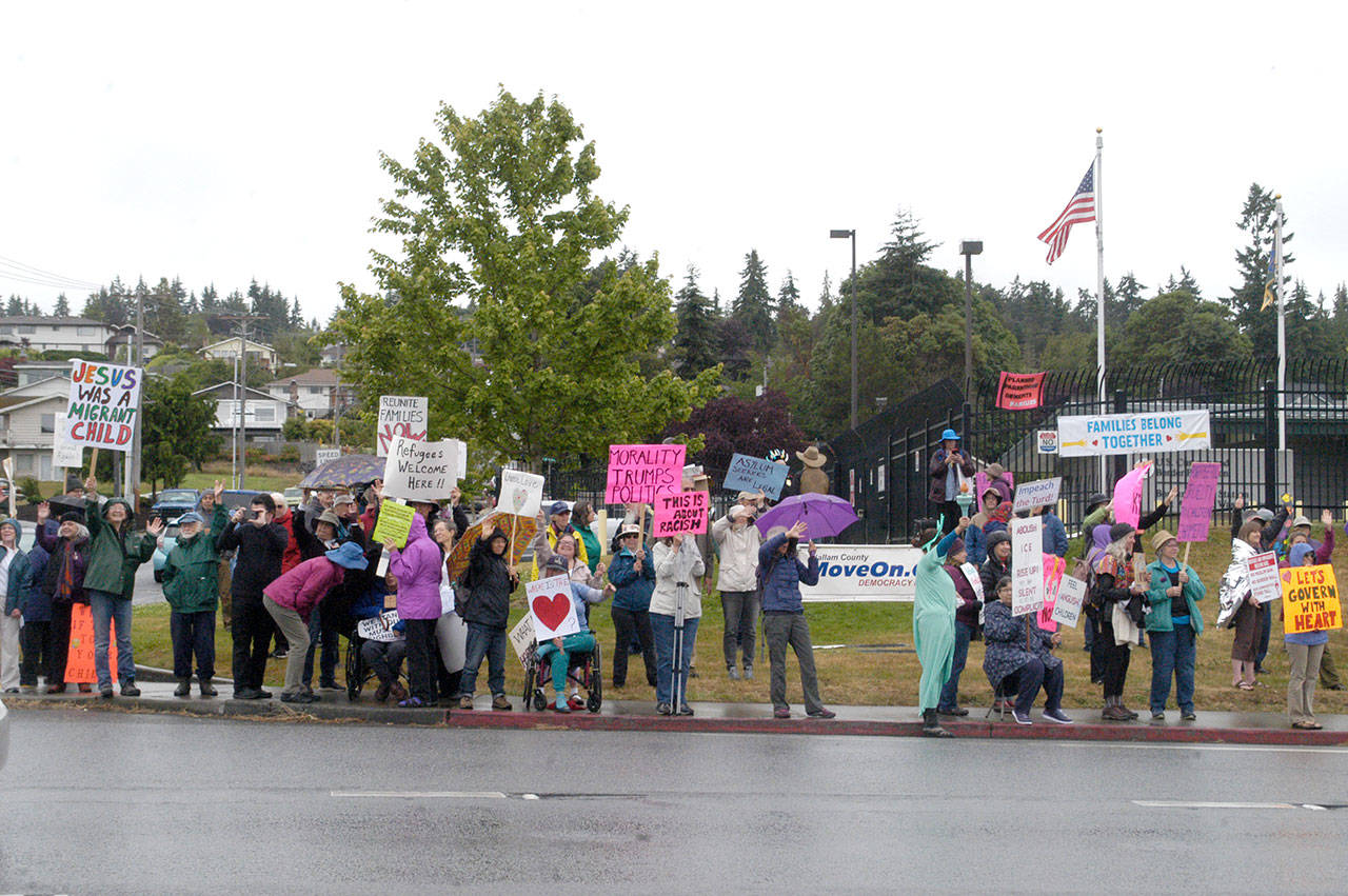 Protesters gather for a Families Belong Together rally near the U.S. Border Patrol building in Port Angeles on Saturday. Similar rallies were taking place across the country to protest federal immigration policies. (Rob Ollikainen/Peninsula Daily News)
