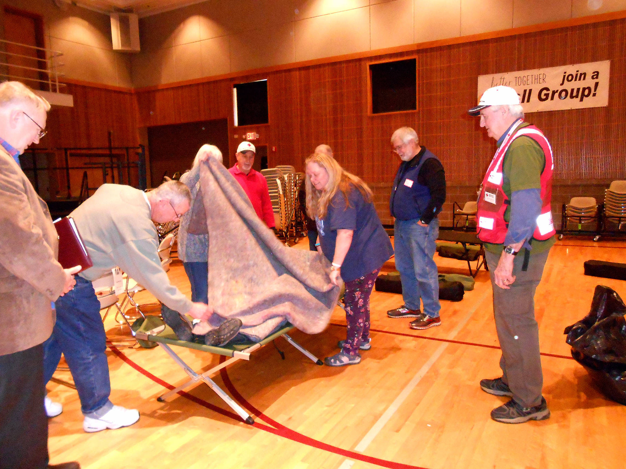 Volunteers with the Red Cross of Kitsap and Olympic Peninsulas help a trainee during a recent Shelter Training event. The local chapter in Carlsborg recently consolidated into one suite and volunteers seek space to store resources across Clallam County. Photo courtesy of Deb Wozniak