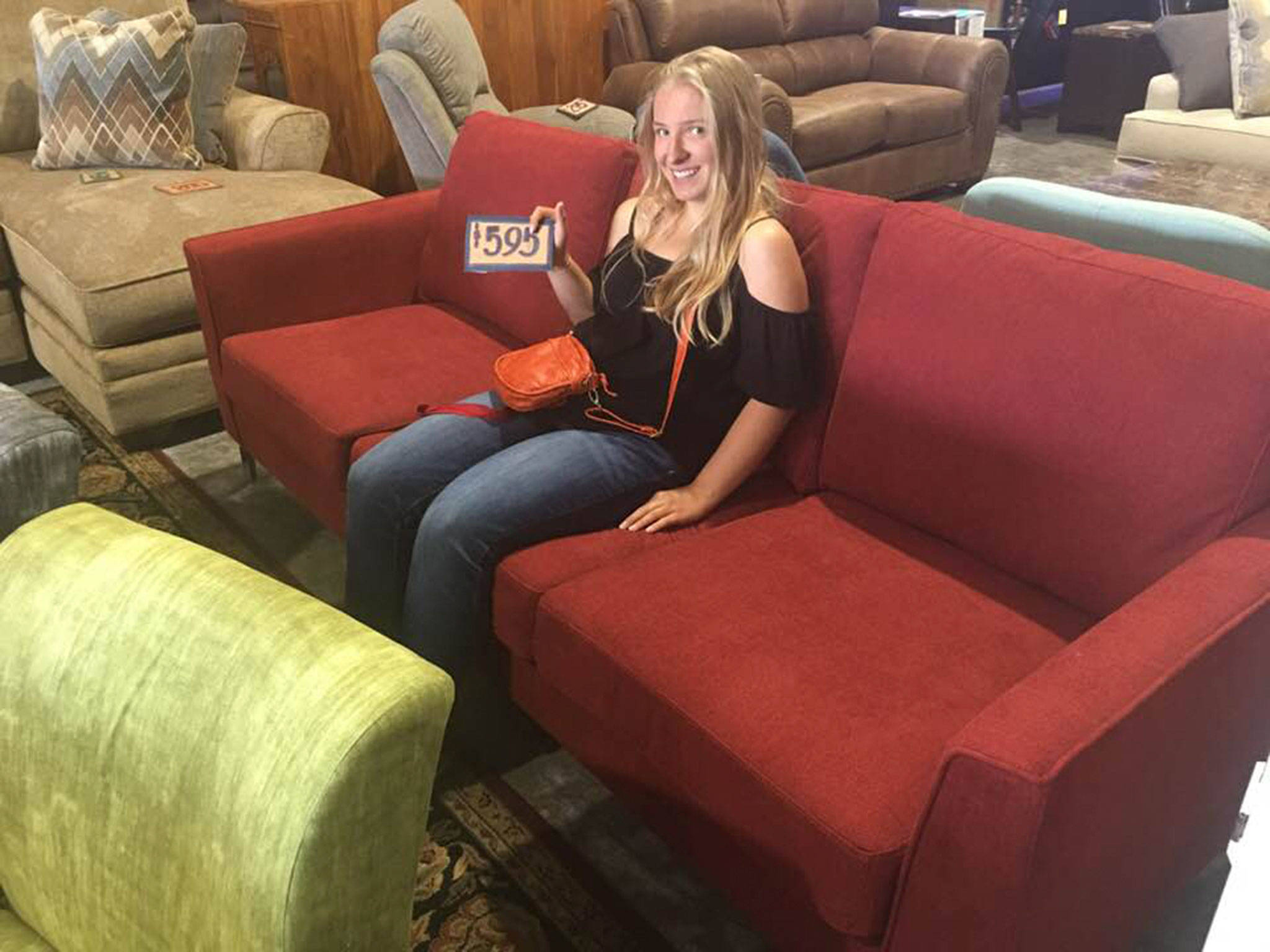 The “Night at the Museum” fundraiser event on Sunday, Aug. 12, is raising monies for the Robby Streett Legacy Fund to purchase new furniture for the Sequim High School Library, in honor of Robby Streett. Annie Armstrong, one of the organizers of the event sits on a couch at The Warehouse in Port Angeles in search of new furniture. Submitted photo