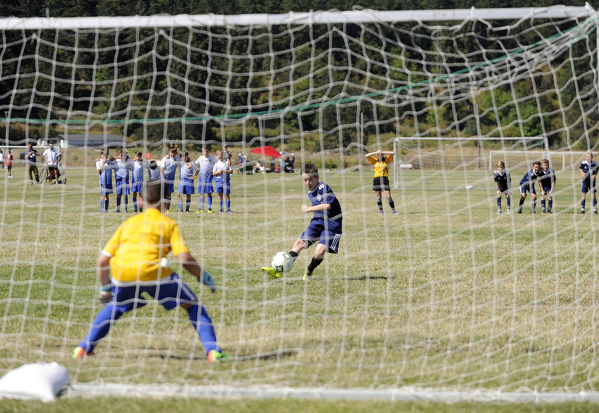 Ky Anderson rips a shot into the lower left corner to clinch a win for his Storm King BU07 squad, as the local team edged NK Kraken 3-2 in penalty kicks in the BU12 title tilt. Sequim Gazette photo by Michael Dashiell