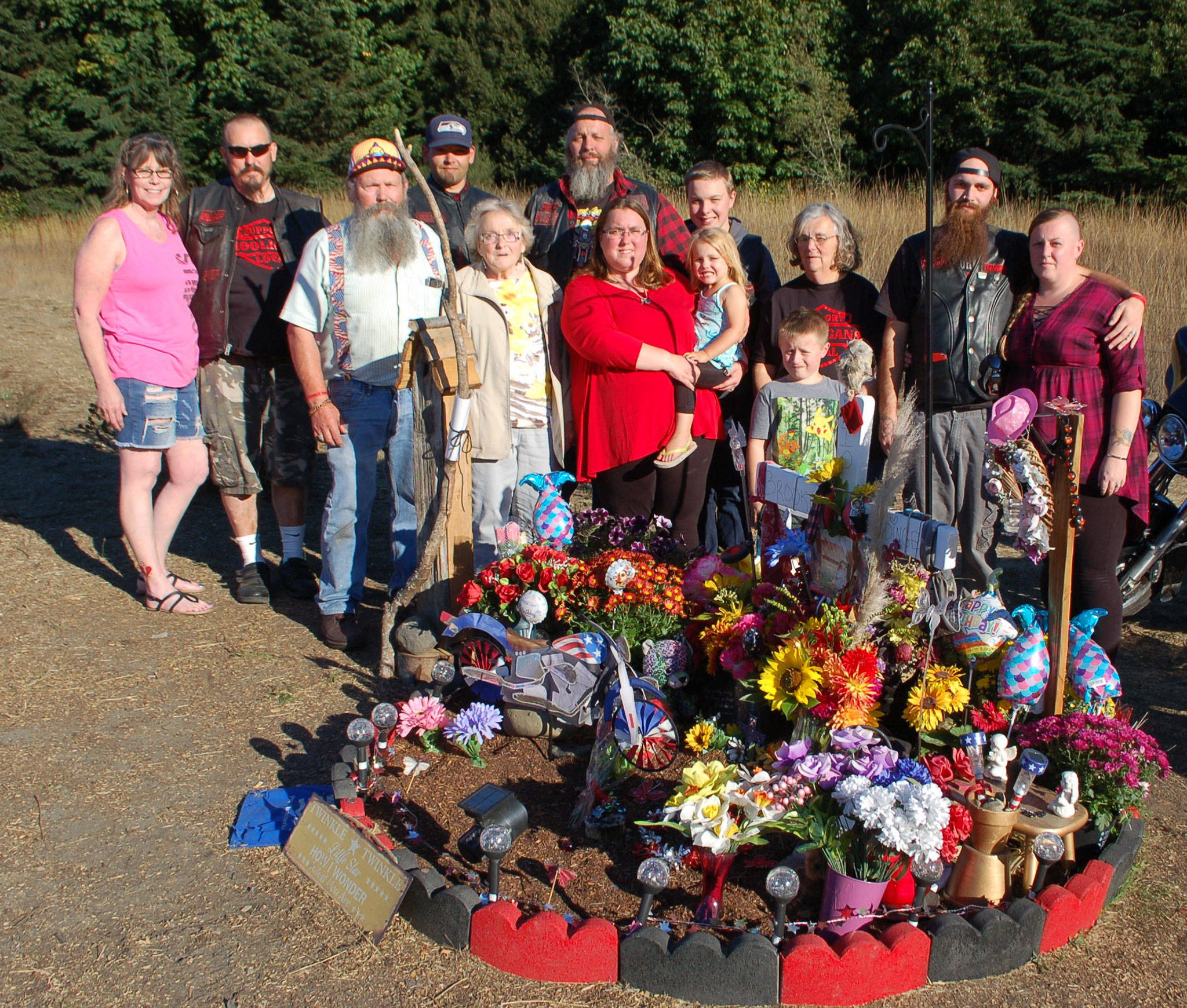 Brooke Bedinger’s family stands at her memorial on the side of US Highway 101 at the Morse Creek curve east of Port Angeles near the site where she died in a motorcycle wreck on June 21. From left, Pat Poage, Brooke’s uncle Woody Johnson, grandfather Gary Johnson, grandmother Debbie Johnson, uncle Josh Robbins, father Don Bedinger, mother Kim Bedinger with niece Ella Bedinger, brother Chase Bedinger, nephew Corbin Alves, grandmother Kathy Bedinger, brother Donald Bedinger and sister-in-law Katy Bedinger, stand together. Sequim Gazette photo by Erin Hawkins